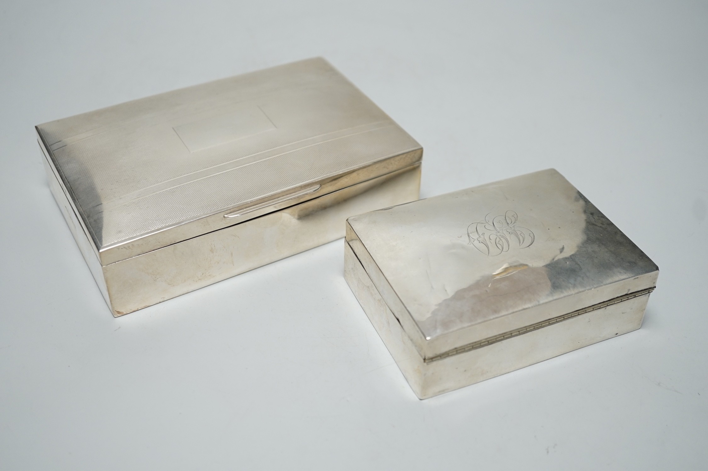 A modern part engine tuned silver mounted cigarette box, 17cm and one other smaller silver mounted cigarette box.